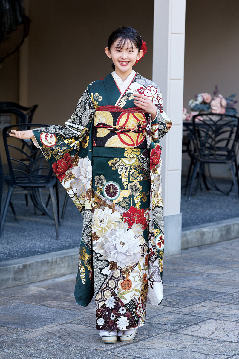 深みのある緑地に大輪の白い牡丹と金彩の古典紋様が映える、気品に満ちた豪華振袖。落ち着きと華やかさを両立させた、大人っぽい二十歳のスタイル。