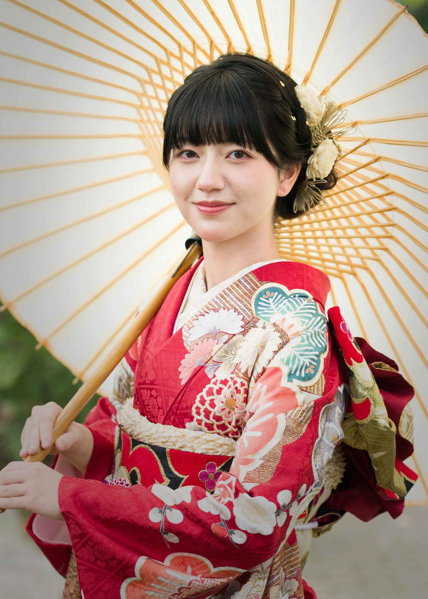 三原市・冨士写真館の成人式振袖前撮り。白い和傘を差し、古典柄の赤い振袖を美しく着こなしたお嬢様のポートレート撮影例