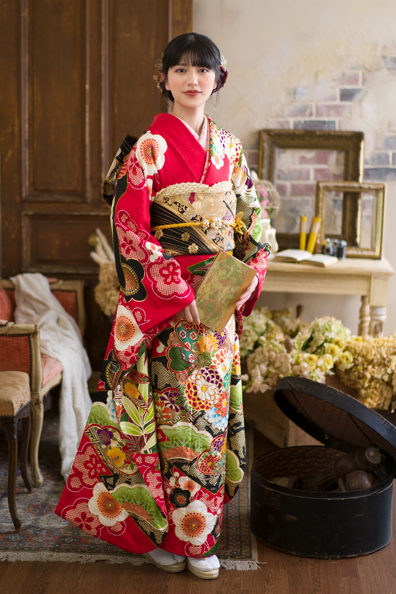 三原市で叶える、レトロモダンな成人式。深みのある赤に豪華な古典花が映える振袖。スタジオ撮影で引き立つ、二十歳の知的で優美な佇まい。