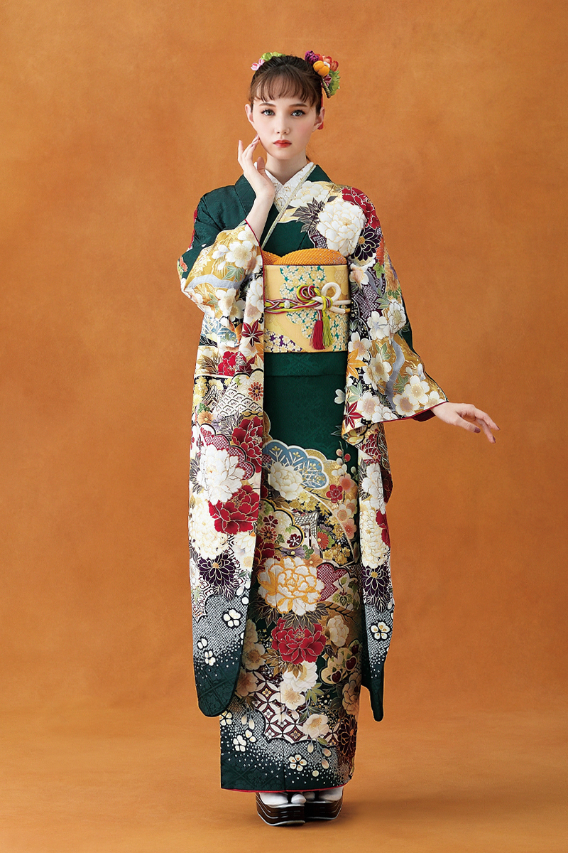 深い緑地に白や赤の大輪の牡丹が咲き誇る、格調高い古典柄振袖。ゴールドの帯とオレンジの小物を効かせた、気品あふれる豪華な成人式の装い。